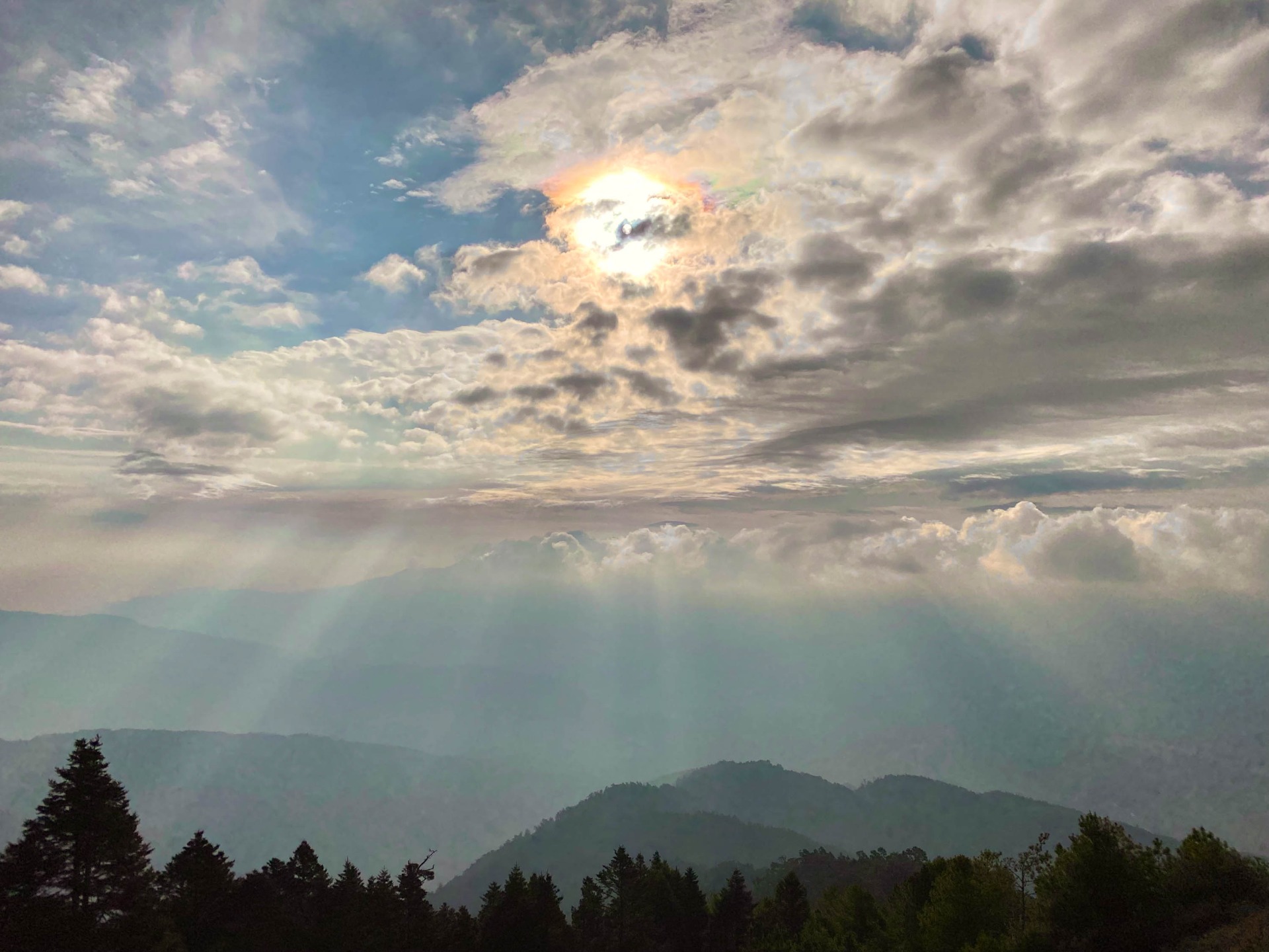 瓢簞山屋草原上，太陽幻化出七彩光和雲隙光。太亮了，原本是拍不下來的，卻有那麼一個瞬間，雲稍微攏來，讓我的手機得以捕捉。